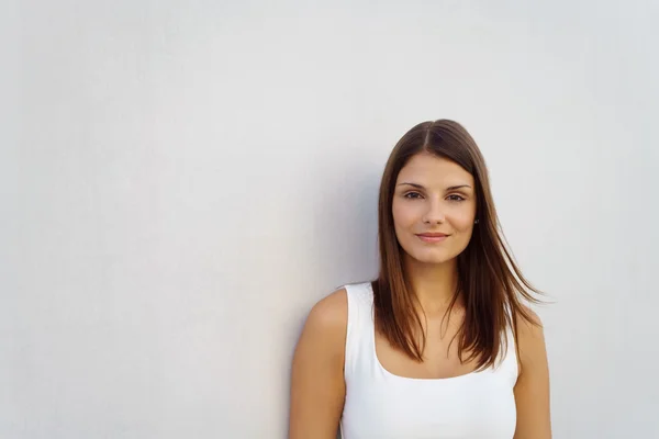 Sourire jeune femme debout près du mur vide — Photo