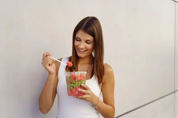 Joven saludable disfrutando de una merienda de ensalada de frutas — Foto de Stock