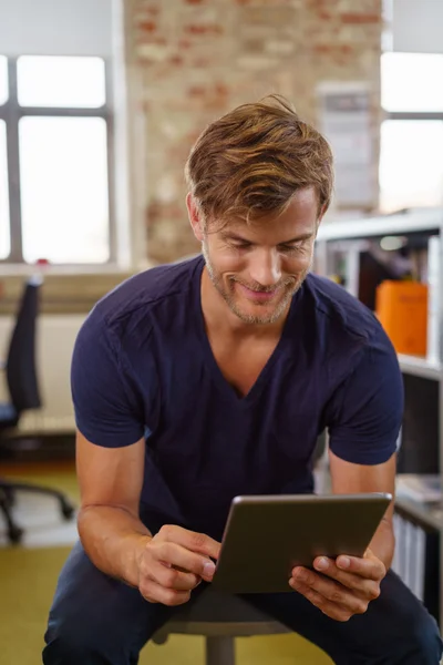 Χαμογελαστός επιχειρηματίας κοιτάζοντας τα δεδομένα του tablet του — Φωτογραφία Αρχείου