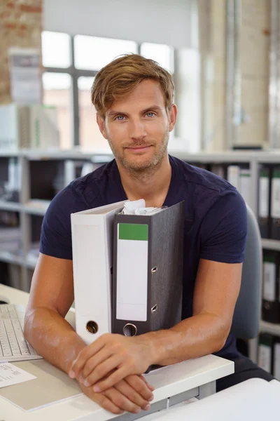 Relaxed dedicated businessman with office binders