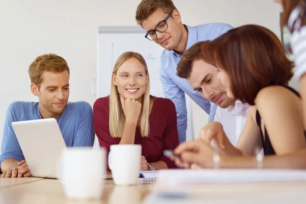 Lycklig kvinna med medarbetare som tittar på rapport — Stockfoto