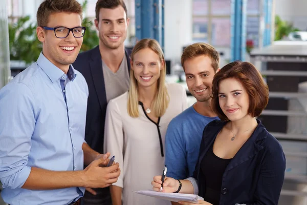 Five workers standing together taking notes — Stock Photo, Image