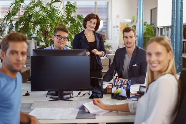 Attraenti lavoratori adulti seduti intorno al tavolo — Foto Stock