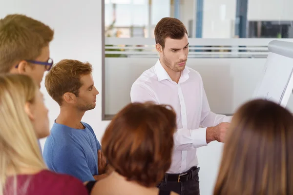 Man står med grupp människor inomhus — Stockfoto