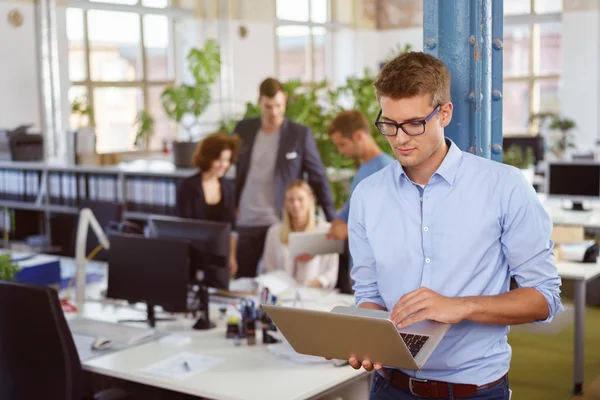 Jungunternehmer arbeitet an einem tragbaren Laptop — Stockfoto