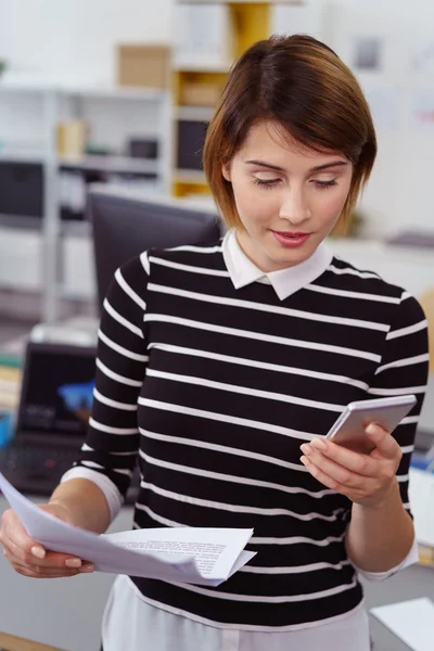 Netjes gekleed kantoormedewerker controleert haar telefoon — Stockfoto