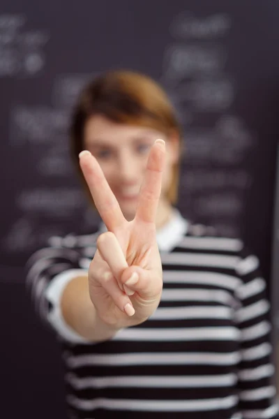 Щаслива жінка робить V-знак з її пальцями — стокове фото