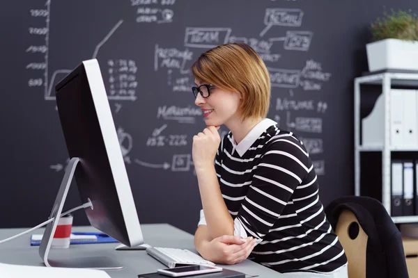 Junge Geschäftsfrau liest ihren Monitor — Stockfoto