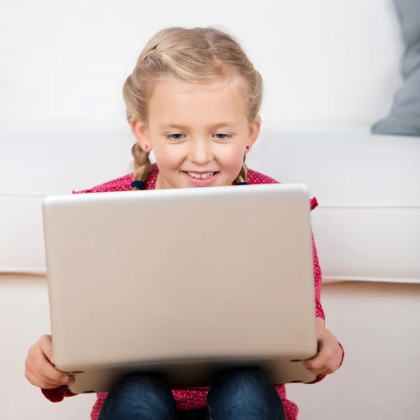 可爱的小女孩看着笔记本电脑 — 图库照片