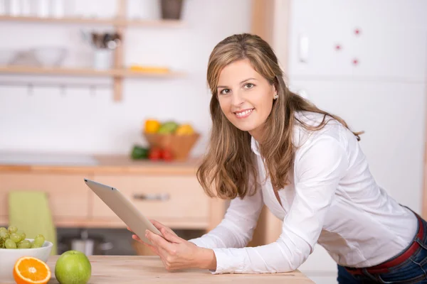 Mulher usando almofada digital na cozinha — Fotografia de Stock