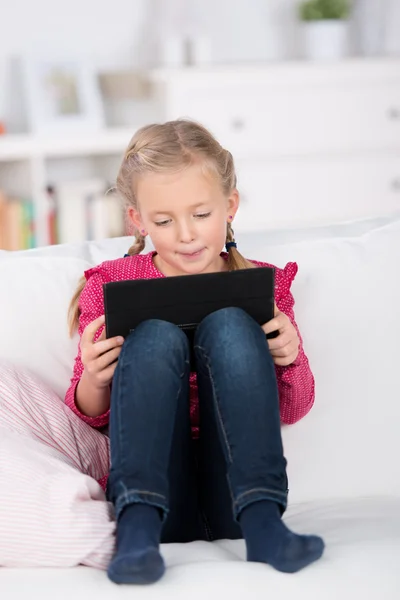 Schoolgirl reading on digital pad — Stock Photo, Image