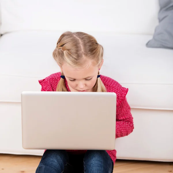 Девушка сидит на полу с ноутбуком — стоковое фото