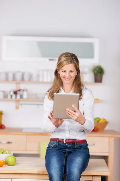 Женщина с цифровым планшетом на кухне — стоковое фото