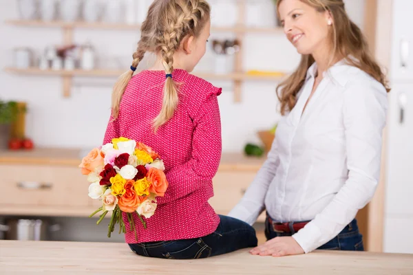 Menina segurando flores por mãe — Fotografia de Stock