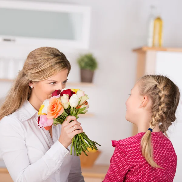 Flicka ger blommor till mor — Stockfoto