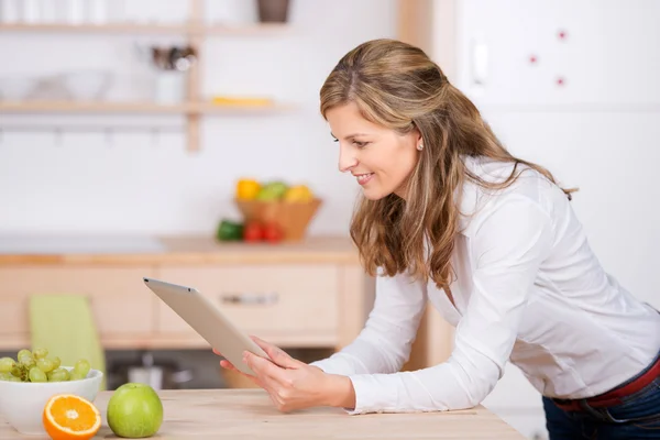 Mulher usando almofada digital na cozinha — Fotografia de Stock