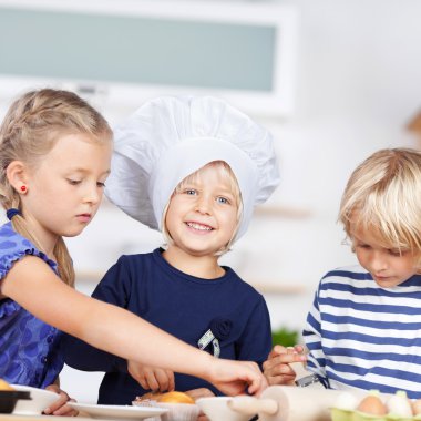 Cute little sisters baking cupcakes clipart