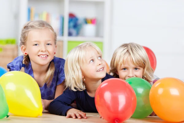 Маленькие девочки с цветными воздушными шарами — стоковое фото