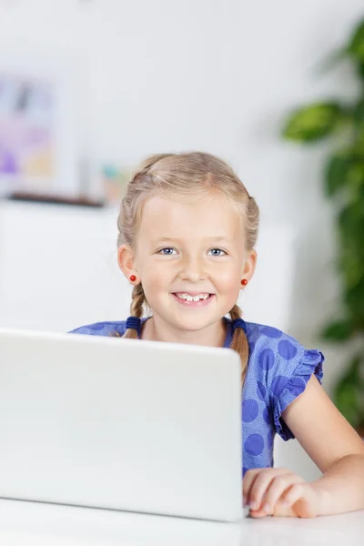 Schoolgirl using laptop — Stock Photo, Image