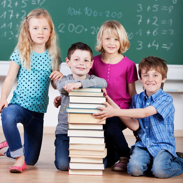 Школьники с большой стопкой книг — стоковое фото