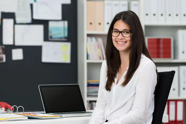 Heureuse femme d'affaires assise au bureau — Photo