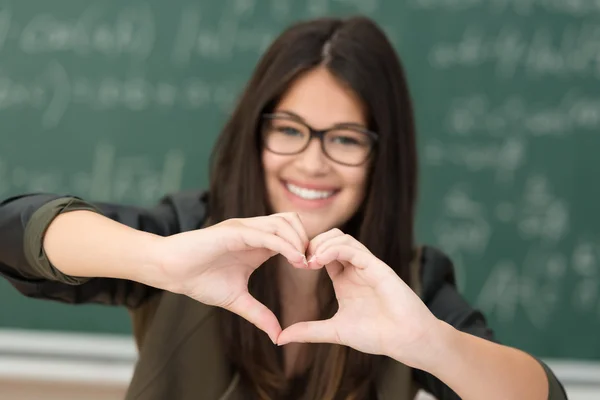 Ragazza sorridente che fa il gesto del cuore — Foto Stock