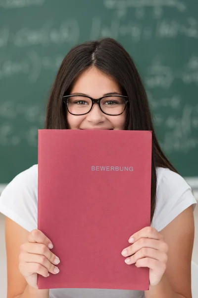 Roztomilý usměvavý mladý student drží souboru — Stock fotografie