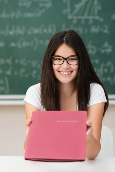 Sorrindo menina atraente segurando um CV em um arquivo — Fotografia de Stock