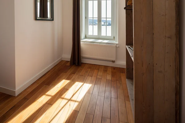 Slunce svítí na dřevěné parketové podlahy — Stock fotografie