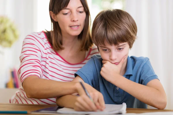 Junge Mutter macht Hausaufgaben mit ihrem Sohn — Stockfoto