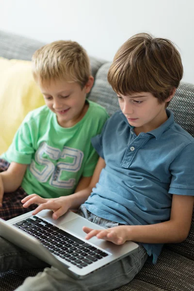 Dizüstü bilgisayar kullanan iki genç kardeş — Stok fotoğraf