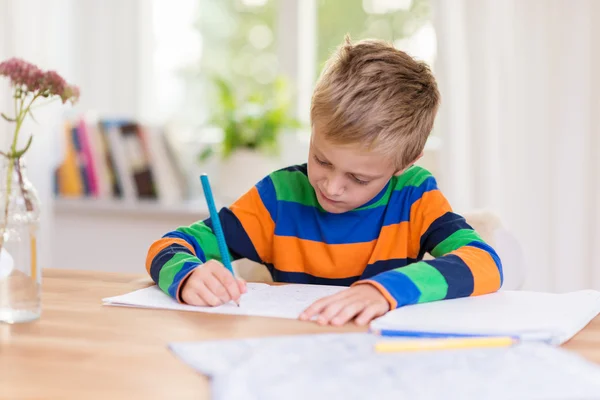 Молодий хлопчик працює над домашнім завданням свого класу — стокове фото