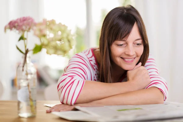 Attraktive Frau entspannt Zeitung lesen — Stockfoto