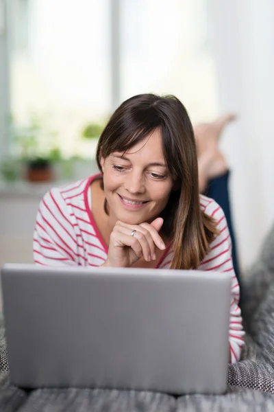 Mulher relaxante em casa com um laptop — Fotografia de Stock