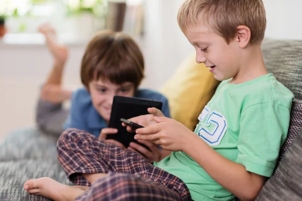 Deux jeunes frères se relaxent avec leurs tablettes — Photo