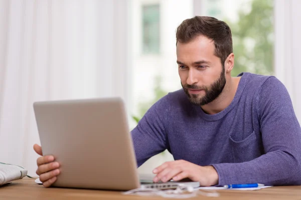 Uomo che lavora sul suo computer portatile a casa — Foto Stock