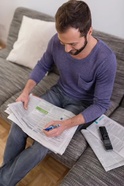 Man belyser reklam i en tidning — Stockfoto