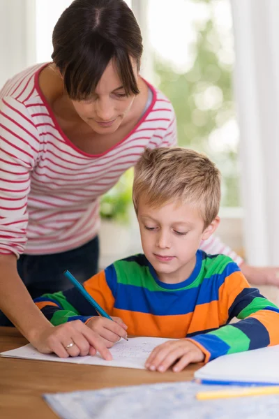 Lärare hjälpa en ung pojke i skolan — Stockfoto