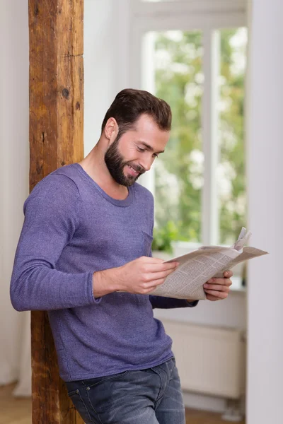 Entspannter Mann steht beim Lesen einer Zeitung — Stockfoto