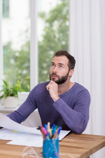 Man sitter tänkande vid sitt skrivbord — Stockfoto