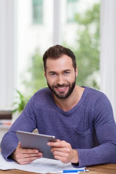 Sonriente hombre feliz trabajando con una tableta — Foto de Stock