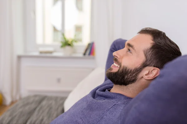 Glücklicher Mann entspannt zu Hause tagträumend — Stockfoto