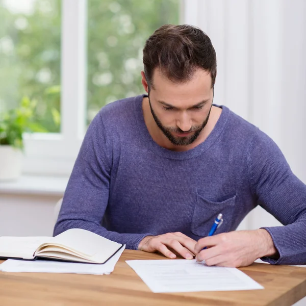 Man working on paperwork at home Stock Picture