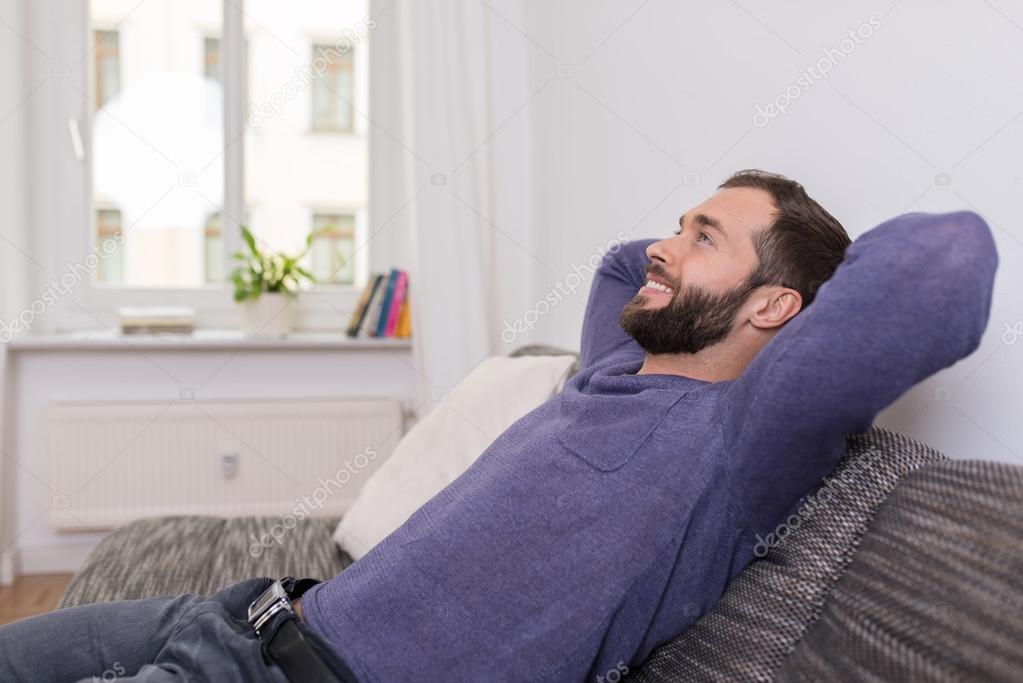 Successful man relaxing on the sofa at home — Stock Photo © racorn ...