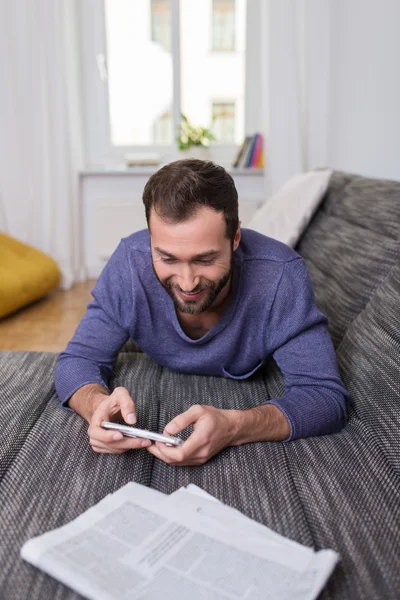 Hombre relajándose en casa en el sofá — Foto de Stock