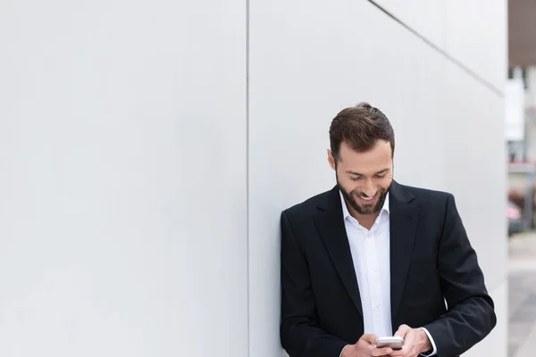 Glückliche gutaussehende Geschäftsmann SMS am Telefon — Stockfoto