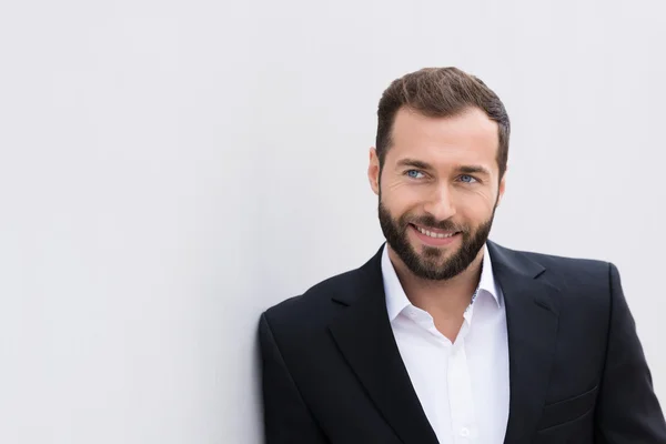 Hombre de negocios de la Edad Media sonriente apoyado en la pared — Foto de Stock