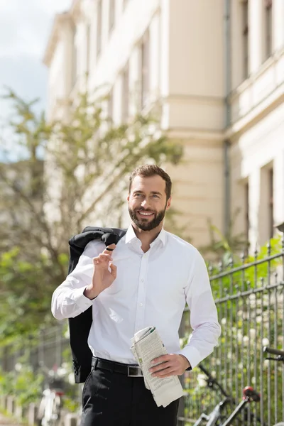 Empresario guapo con periódico en la calle — Foto de Stock