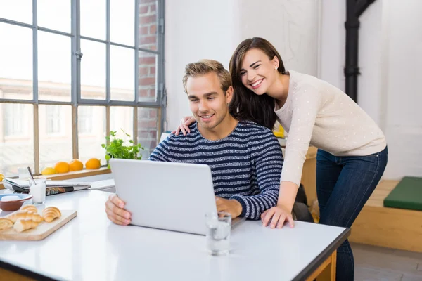 Affectionate happy couple using a laptop — Stock Photo, Image