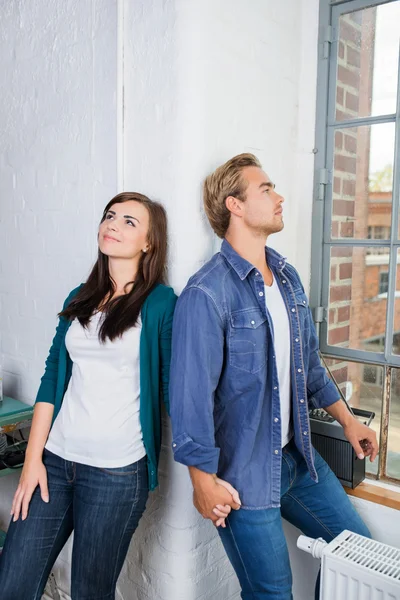 Young couple standing daydreaming — Stock Photo, Image